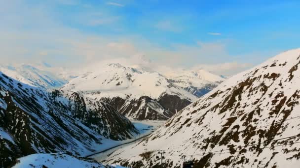 Soligt bergslandskap med bergbana och snö — Stockvideo