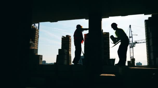 Construction du mur de briques tenu par des ingénieurs masculins — Video