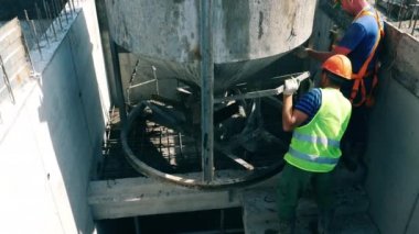 Masonluk işçileri teneke kutudan beton döküyor.