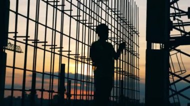 İnşaat işçileri, inşaatçılar gün batımında çalışıyorlar.