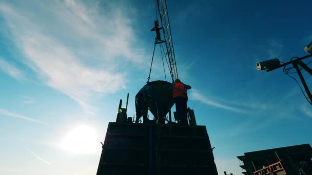 Dois construtores em uma plataforma alta estão trabalhando com uma cisterna — Vídeo de Stock