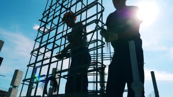 Trabajadores de la construcción están haciendo una carcasa de metal al aire libre — Vídeos de Stock