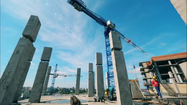 Mouvement rapide de la grue se déplaçant sur le chantier avec des personnes — Video