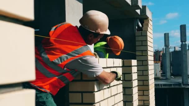 Muro de ladrillo está siendo procesado por los trabajadores de la construcción — Vídeos de Stock