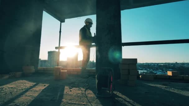 건설 현장, 건설 산업, 건설 노동자 개념. 기계로 모래를 쌓는 남성 기술자. — 비디오