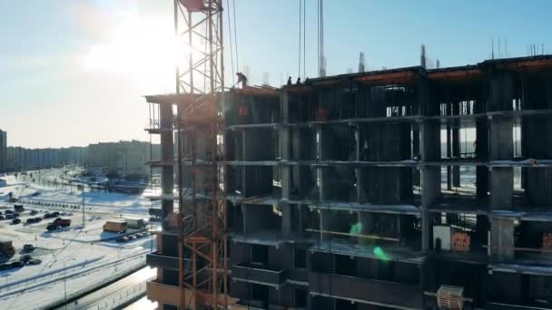 Muchos constructores trabajan en edificios sin terminar en un sitio. Sitio de construcción, industria de la construcción, concepto de trabajador de la construcción . — Vídeo de stock