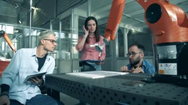 Laboratuvar uzmanları bir çizim robotu üzerinde deney yapıyorlar.