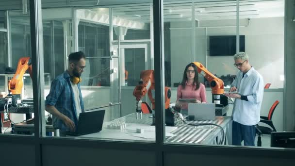 Robotica laboratorium met jonge specialisten en machines — Stockvideo