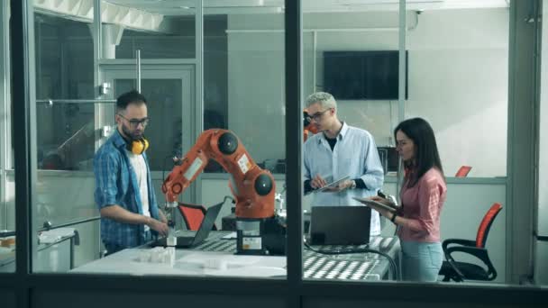Výzkumní pracovníci sledují fungující bionickou ruku. — Stock video