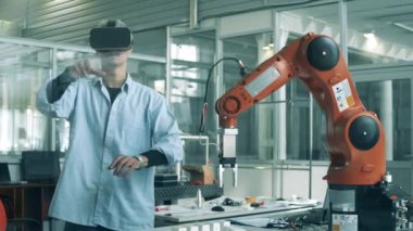 Araştırma görevlisi bir robot kolu yönetiyor.