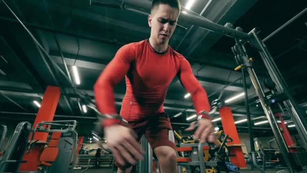 Sportsman está usando una máquina de fitness para estirar los brazos — Vídeos de Stock