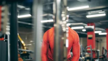 Fitness makinesi bir adam tarafından kollarını yapmak için kullanılıyor.