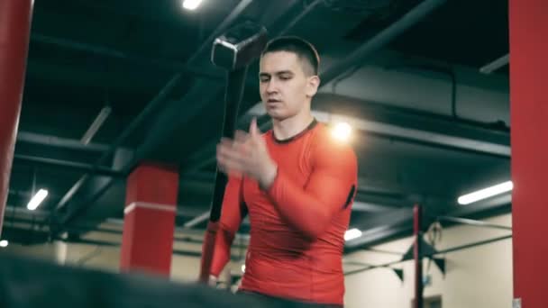 Un homme utilise un marteau pendant sa pratique de crossfit — Video