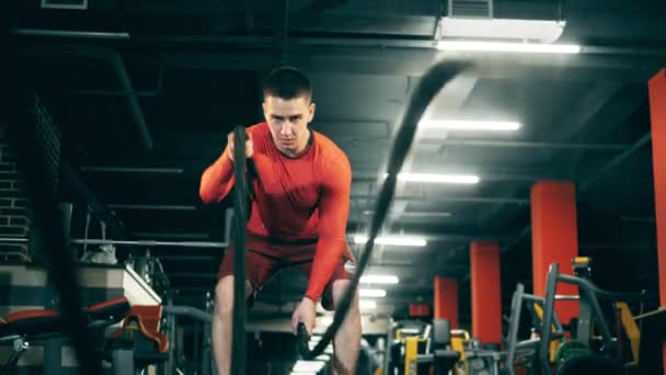 Мужчина делает упражнения по кроссфиту с веревками — стоковое видео