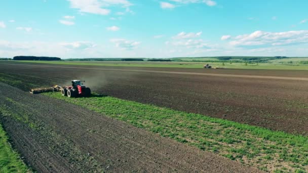 Zwei Traktoren pflügen großes Feld auf einem Bauernhof. — Stockvideo