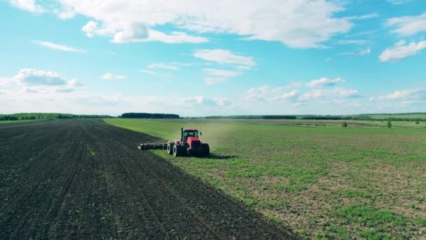 Agricultural tractor works on a field, plowing. — Stock Video