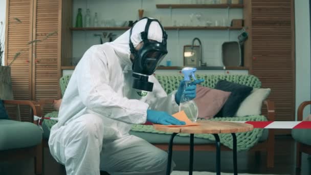 Ein Desinfektor desinfiziert Tisch mit Antiseptikum im Raum. — Stockvideo