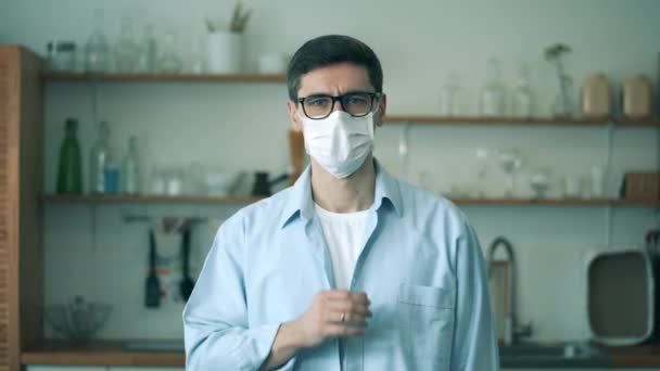 Людина знімає медичну маску, дивлячись на камеру . — стокове відео