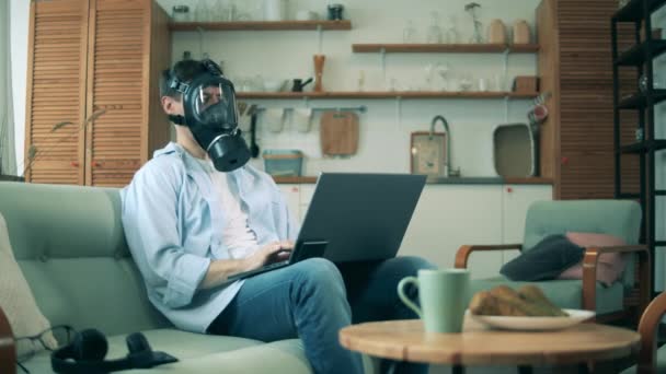 Person in gas mask works from home during pandemic. — Stock Video