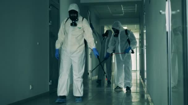 Los trabajadores masculinos en trajes de protección aerosol pasillo . — Vídeos de Stock