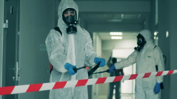 Men use sprayers to sanitize hallway during pandemic. — Stock Video