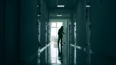 Adamın biri virüsü öldürmek için koridora antiseptik sıkar..