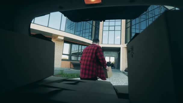 Un hombre está sacando cajas para la entrega del maletero del coche. — Vídeos de Stock