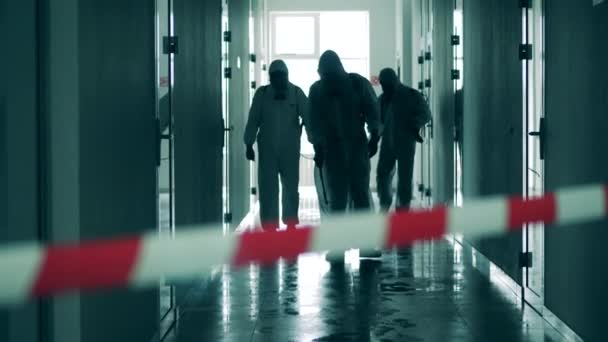 Trabalhadores de saneamento caminham no corredor, pulverizando anti-séptico . — Vídeo de Stock