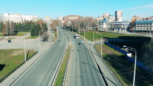 Мало машин едут по дороге в карантинном городе — стоковое видео