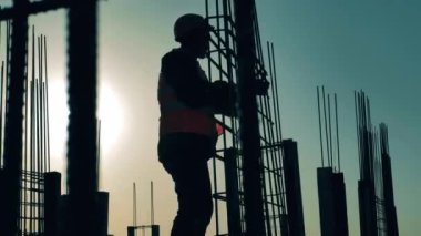 İnşaat işçisi gün batımında bir leşi ayarlıyor.