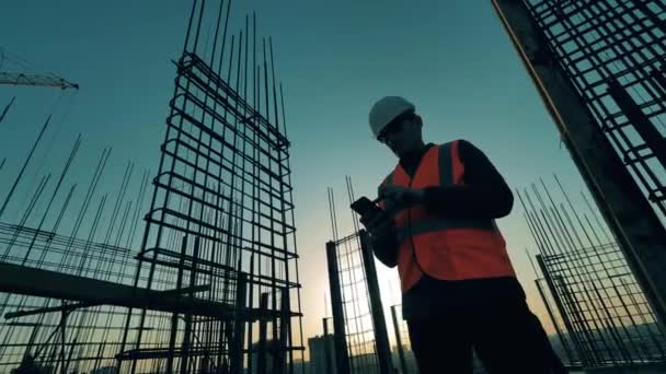 Mannelijke werknemer geeft instructies op de daken van een gebouw — Stockvideo