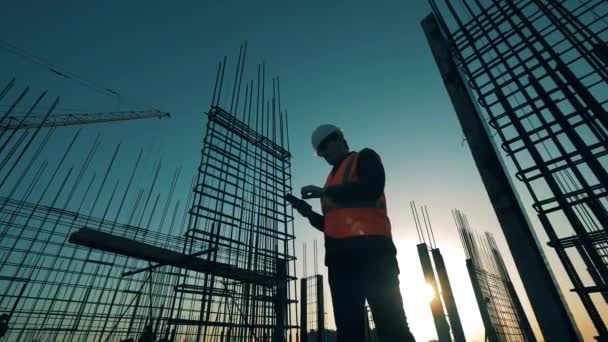 Constructor está haciendo cálculos en el lote de construcción de la azotea — Vídeo de stock