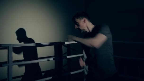 男性アスリートはリングでボクシングのトレーニングを受けています — ストック動画
