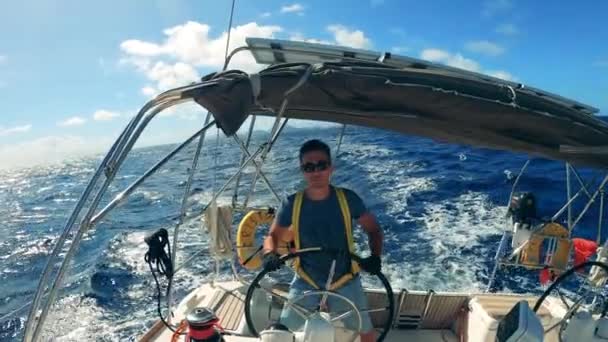 Guy in glasses drives yacht in ocean. — Stock Video