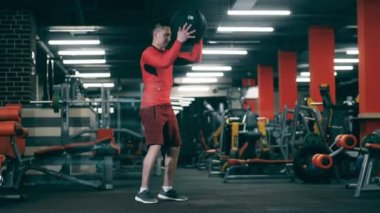 Bir adam topla antrenman yapıyor, düşürüyor..