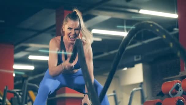 Uma mulher treinando com cordas durante o crossfit . — Vídeo de Stock