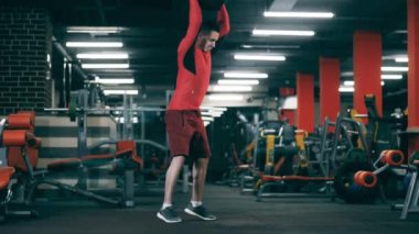 Genç adam spor salonunda topla antrenman yapıyor..