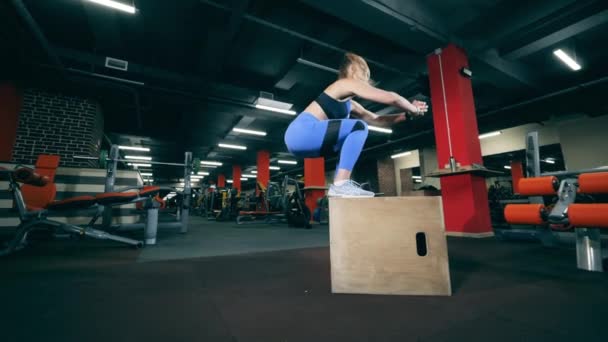 Chica salta en una caja durante el entrenamiento crossfit . — Vídeos de Stock