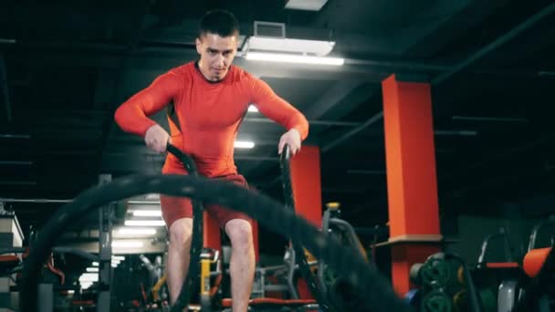 Bir adam Crossfit egzersizi sırasında ipleri çevirir.. — Stok video