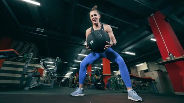 Persona sentadillas con una pelota durante el entrenamiento crossfit . — Vídeos de Stock