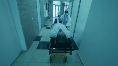 Kadın doktor, bir koronavirüs hastasını sedyeye taşıdı..