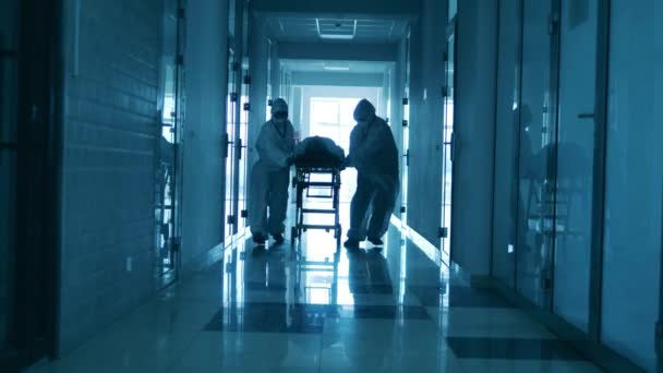 Klinikmitarbeiter bewegen einen Patienten auf einer Trage. — Stockvideo