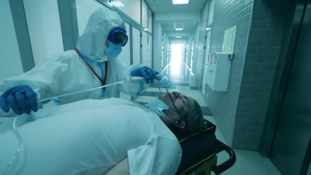 医療従事者は、コロナウイルスの患者に呼吸マスクを置きます. — ストック動画