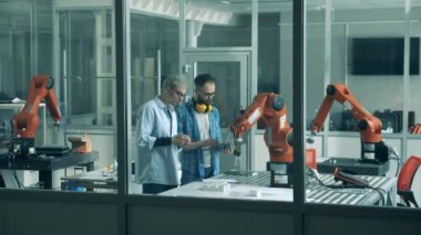 Robot mühendisleri biyonik bir kolu hareket halinde gözlemliyorlar.