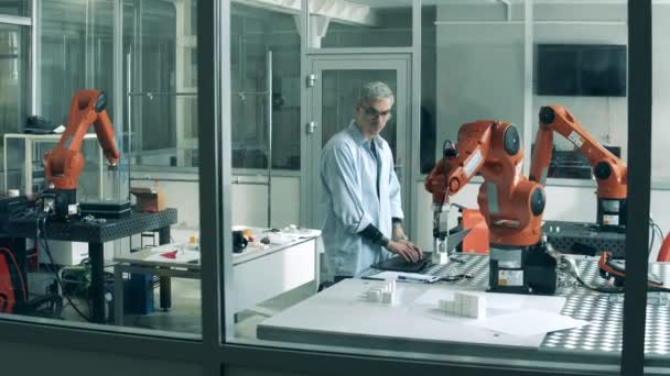 Robotica laboratorium en een software ontwikkelaar observeren van een robot — Stockvideo