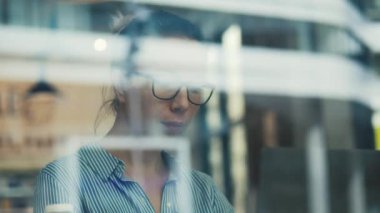 Meyve suyu içerken pencereden bakan muhteşem bir kadın.