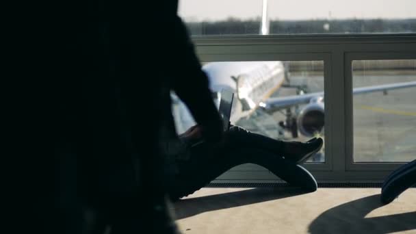 Uma senhora está trabalhando em um computador enquanto espera no aeroporto — Vídeo de Stock