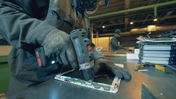 Travailleur de l'usine de déchets prend tablette en morceaux pour le recyclage. — Video