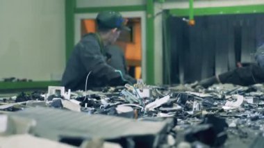 Üniformalı adamlar nakliye aracındaki çöpleri düzenliyor..