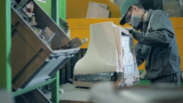 Trash, e-waste, electronic garbage recycling factory. A person takes apart an old monitor at recycling center. — Stock Video